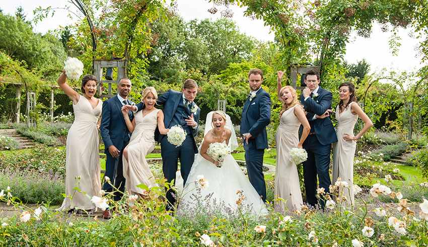 Bridal party in the rose garden at Great Fosters, a Surrey wedding venue