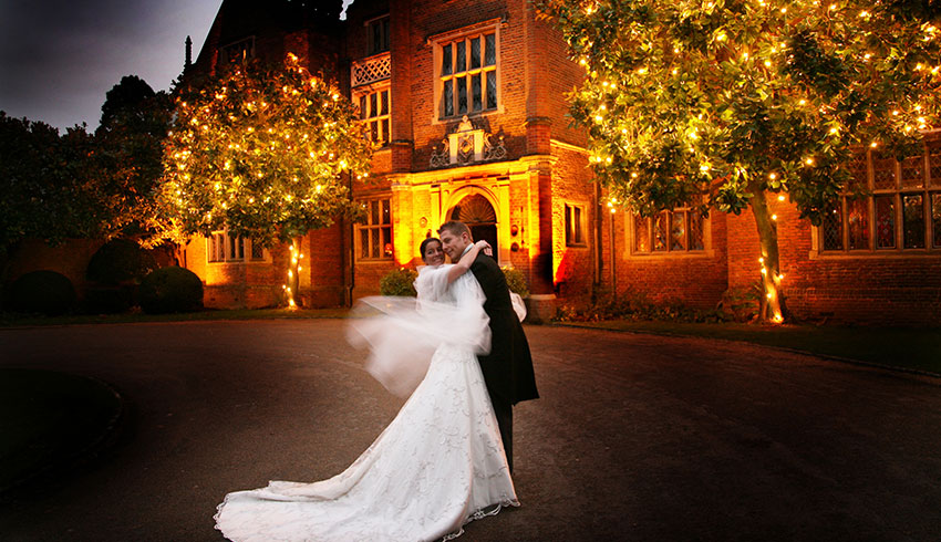 Bride and Groom outside the front of Great Fosters at night