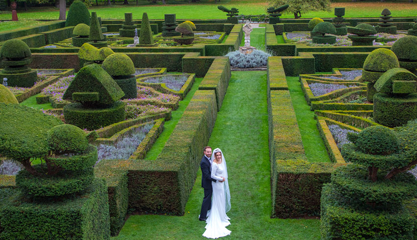 Bride and Groom by the topiary at Great Fosters