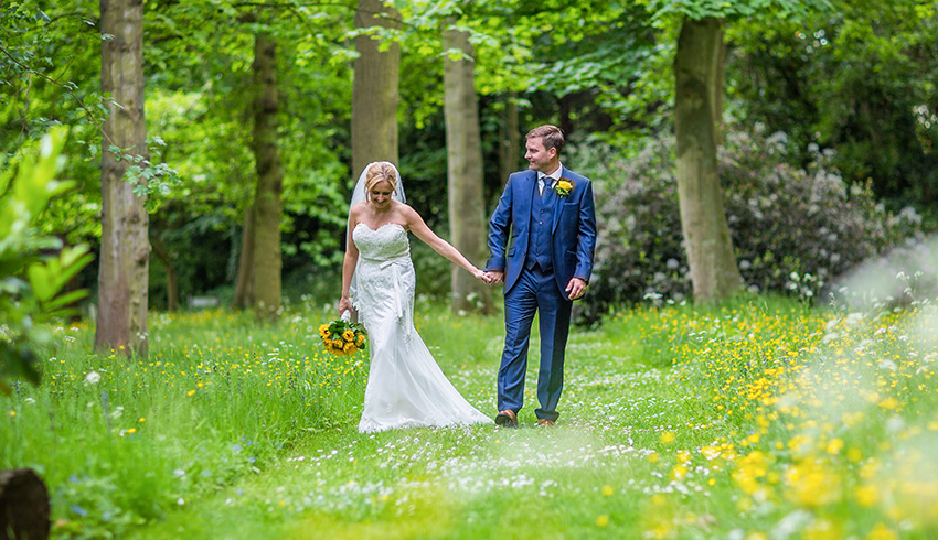 Wedding couple walking through the grounds of Rowhill Grange & Utopia Spa, Kent wedding venue