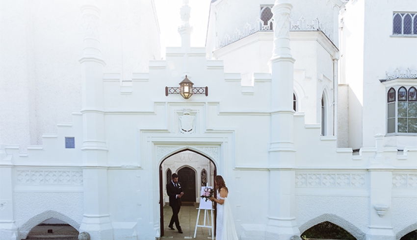 Wedding couple outside the white gothic castle wedding venue Strawberry Hill House