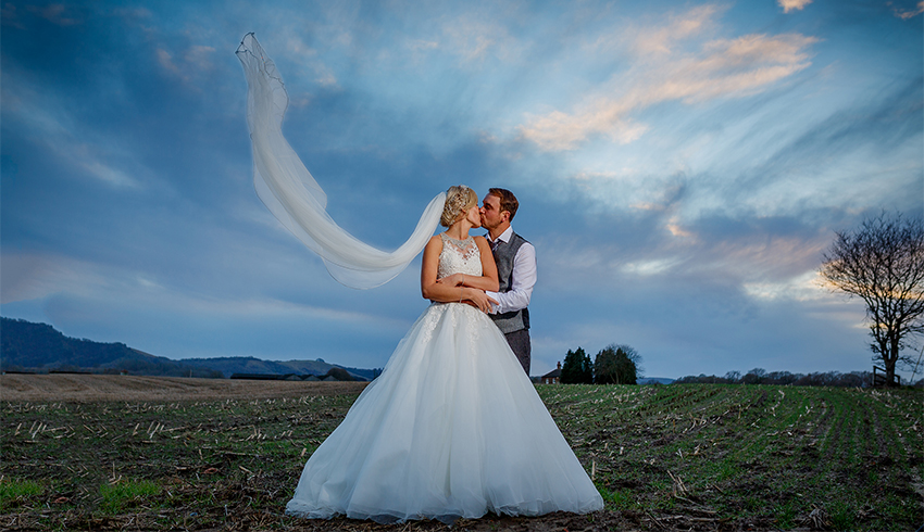 Wedding couple standing outside in Southdowns Manor with a blue sky